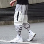 Light grey men’s cargo joggers with patch pockets, elastic cuffs and streetwear styling.

