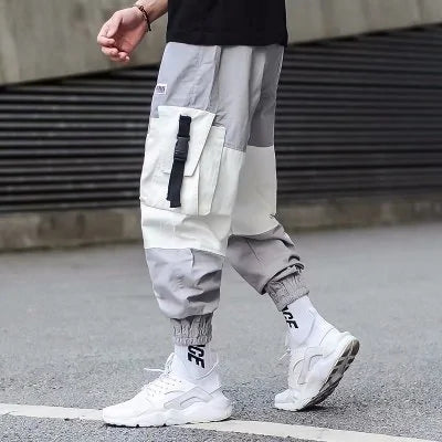 Light grey men’s cargo joggers with patch pockets, elastic cuffs and streetwear styling.
