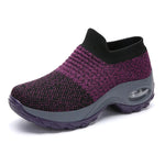 A vibrant red athletic sneaker featuring a breathable knit upper, lace-up design, and a unique, futuristic sole with hollowed cushioning pods for enhanced flexibility and support.