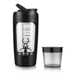 Portable black electric blender bottle with a clear mixing chamber marked with measurements up to 500 ml and a power button on the base, shown beside a small matching lidded cup.