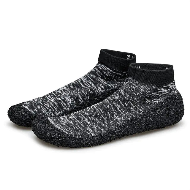 Black grey speckled barefoot water shoes with sock-style ankle cuffs and textured grip soles.
