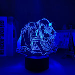 Blue anime-style LED night light showing two characters in an embrace on a round black base.
