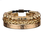 A set of three gold bracelets featuring different designs: one with Roman numerals, one with a braided pattern, and another with decorative beads and black accents.
