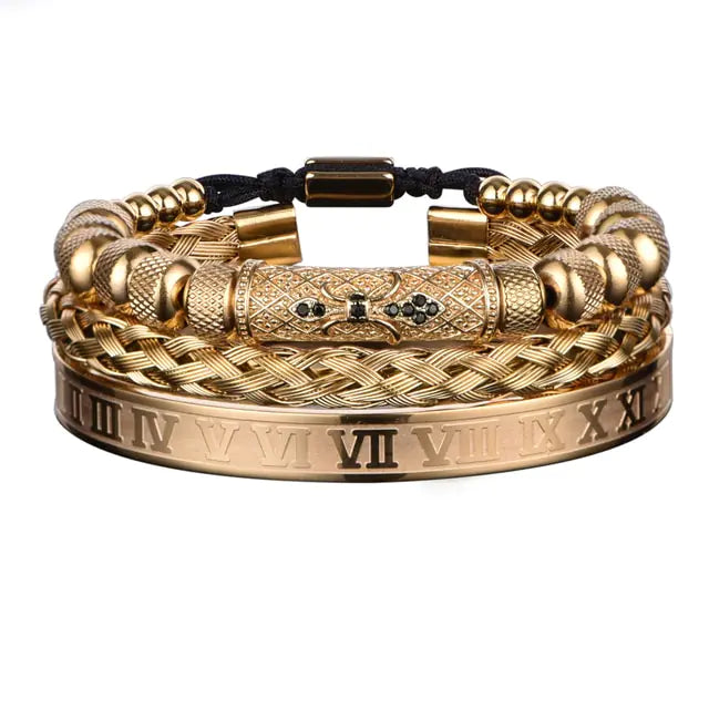 A set of three gold bracelets featuring different designs: one with Roman numerals, one with a braided pattern, and another with decorative beads and black accents.
