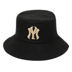 Black bucket hat with a wide downward brim and embroidered beige “NY” logo on the front.