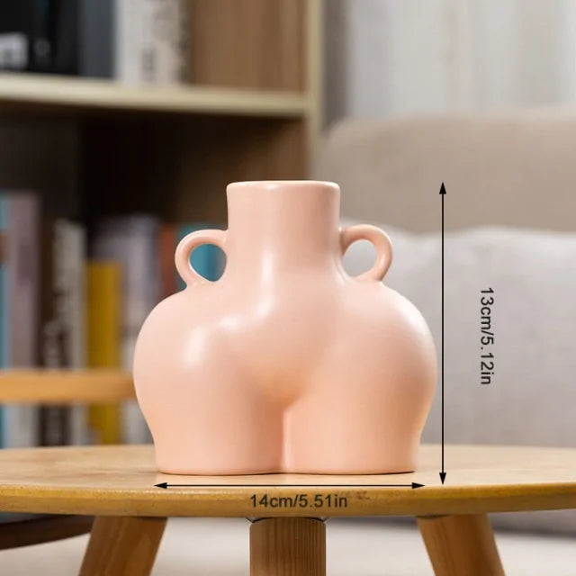 Peach ceramic body-shaped vase with small side handles, measuring about 14 cm wide and 13 cm tall.