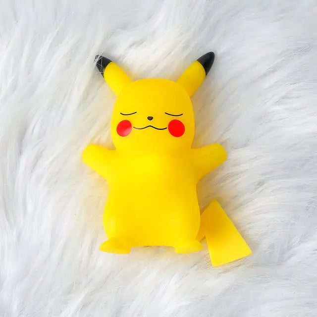 Cute Pikachu figure made of yellow soft plastic, with closed eyes and a smiling expression, set against a fluffy white background.