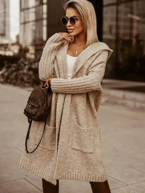 Woman wearing a beige cardigan with a blurred urban background