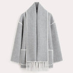 Dark wool coat with white blanket stitch trim, featuring front buttons, large patch pockets, and an attached matching scarf with fringe detailing draped over the shoulder. The coat is displayed against a plain white background.