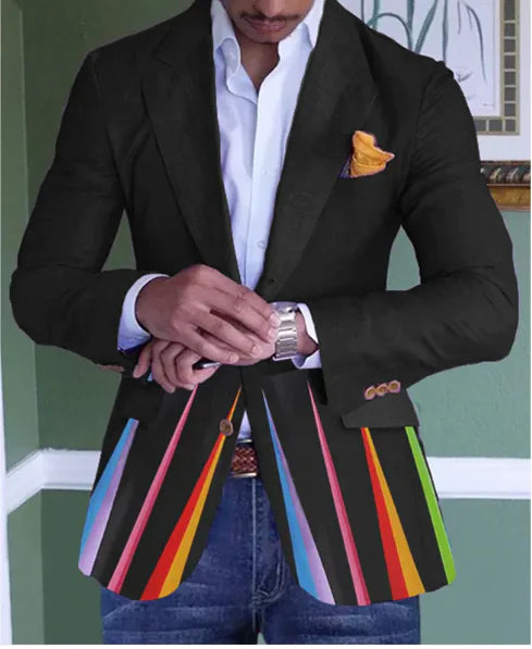  A well-dressed man wears a unique black blazer featuring colorful, diagonal stripes in red, yellow, blue, pink, and green along the lower half. Underneath, he sports a crisp white dress shirt with an open collar, accessorized with a mustard-yellow pocket square. His wrists are adorned with a silver watch. He pairs the blazer with blue denim jeans and a brown belt, creating a mix of formal and casual styles. The background features a green wall with framed artwork, adding an elegant touch to the setting.