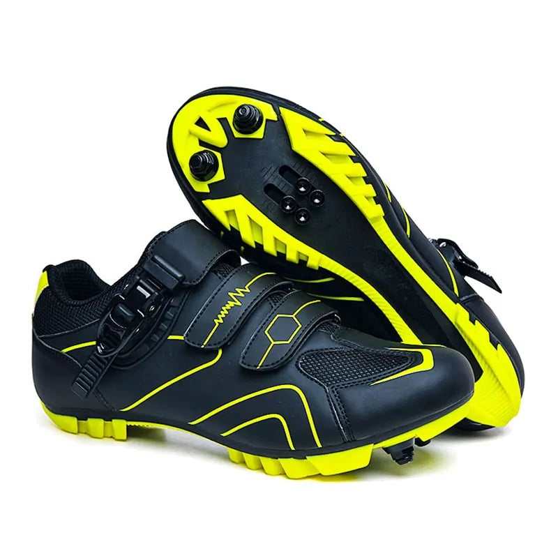 A pair of high-performance black and neon yellow cycling shoes. The shoes feature a sleek design with three closure straps, including a secure ratchet strap. The upper has ventilated mesh sections and bright yellow line accents. The outsoles have cleat attachments and aggressive treads for grip, making them suitable for road or mountain biking. One shoe is upright while the other shows the sole with cleats and lug patterns.
