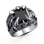 Silver-toned ring featuring a large square black gemstone set in a claw-like design, resembling a dragon’s claws, shown on a white background.