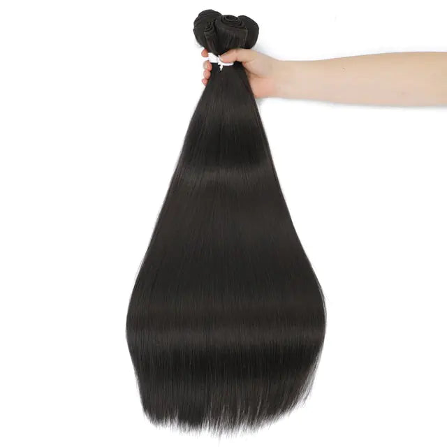 Hand holding a bundle of long, straight black hair extensions (weft at the top) against a white background.