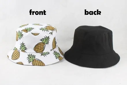 Reversible bucket hat shown from two sides: the front is white with a repeating pineapple print, and the back is solid black, labeled “front” and “back.