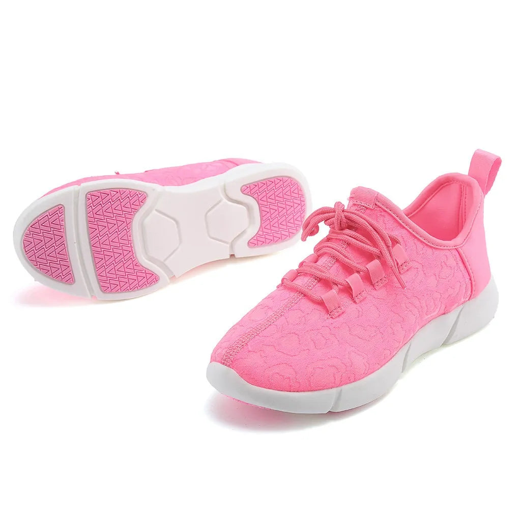 Pink lace-up trainers with white segmented soles and textured uppers.

