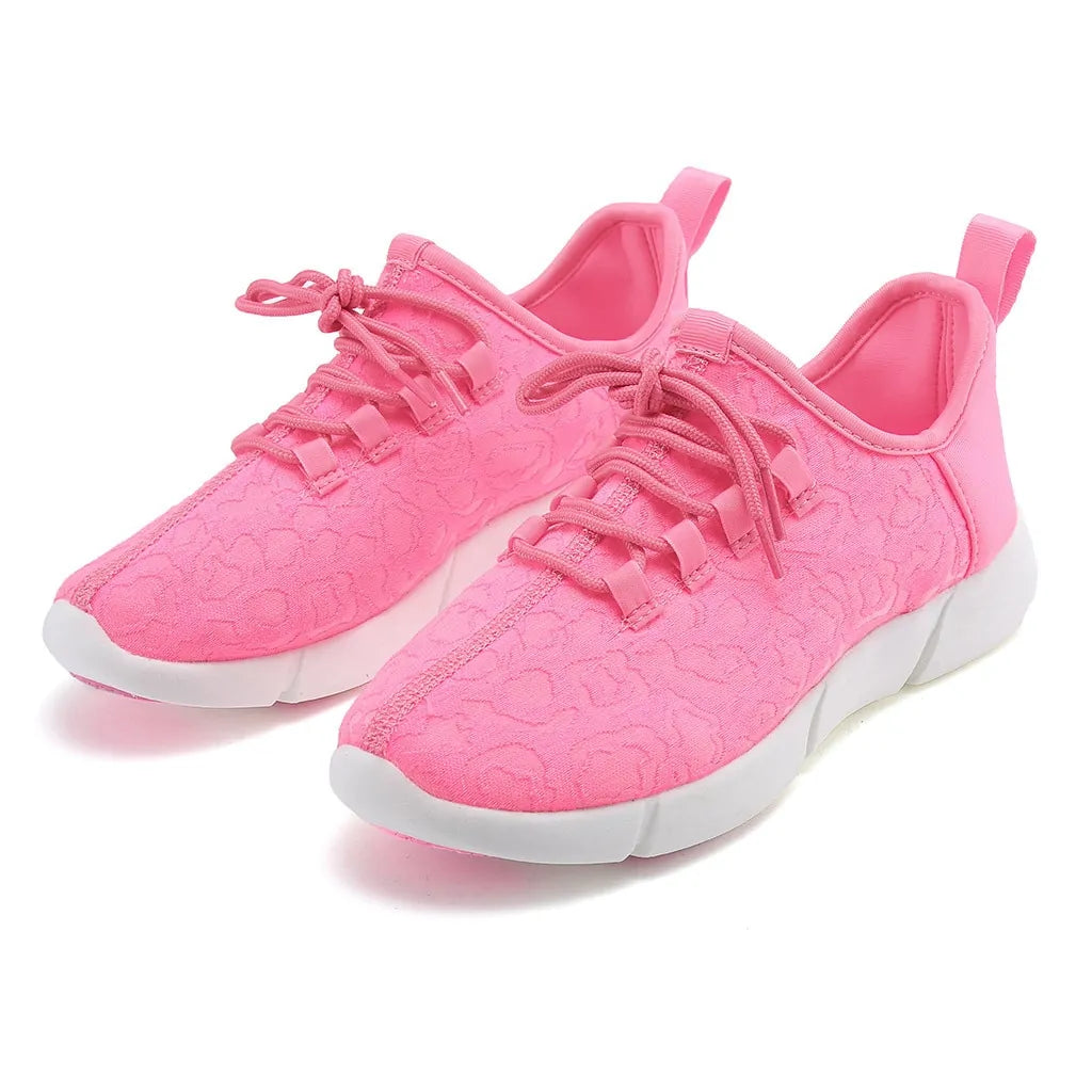 Pink lace-up trainers with floral textured fabric, white chunky soles and rear pull tabs.
