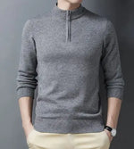 A sleek slim-fit sweater with a quarter-zip collar, worn by a male model against a neutral gray background. The sweater features ribbed cuffs and a ribbed hem for a snug and polished fit. The model pairs it with light-colored trousers and a silver wristwatch, creating a refined and sophisticated look.