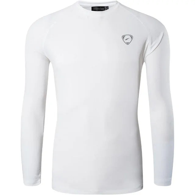 A sleek, light gray long-sleeve compression shirt with a crew neck, featuring a small logo on the upper left chest. The fabric appears smooth and stretchy, designed for athletic or casual wear.