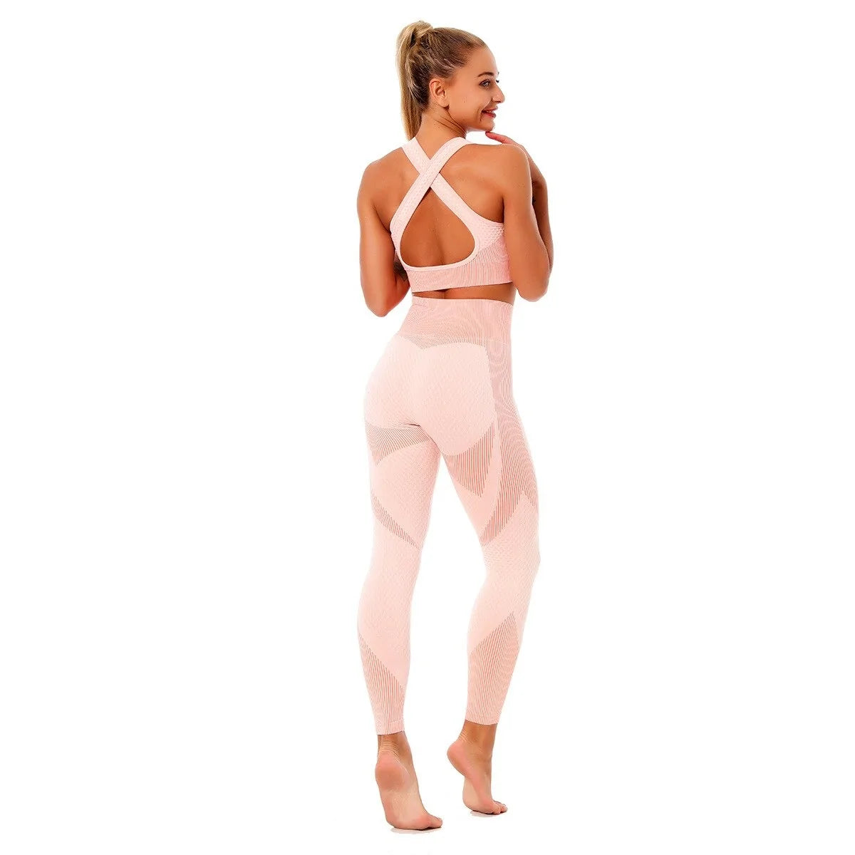 Woman wearing a seamless, textured long-sleeve athletic zip-up top in a light pink and peach gradient, featuring a high collar and thumb holes.